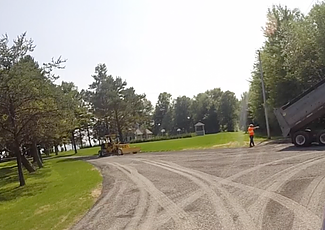 workers applying surface treatment to a road